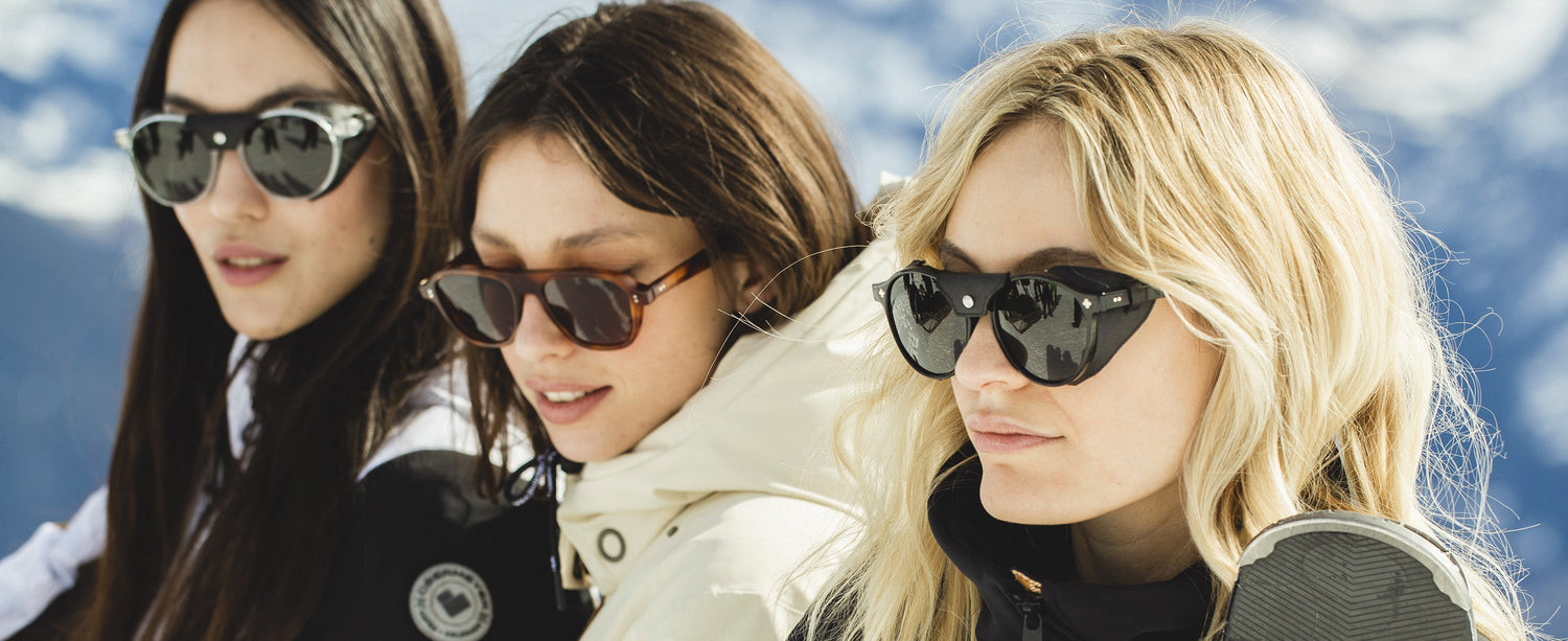 Three female skiiers wearing Obermeyer sunglasses.