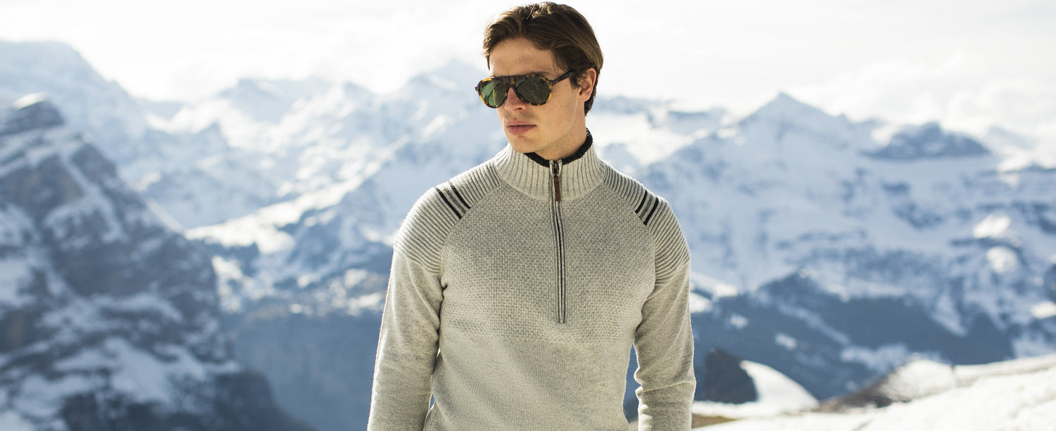 Male skier in an Obermeyer sweater on the top of a mountain.