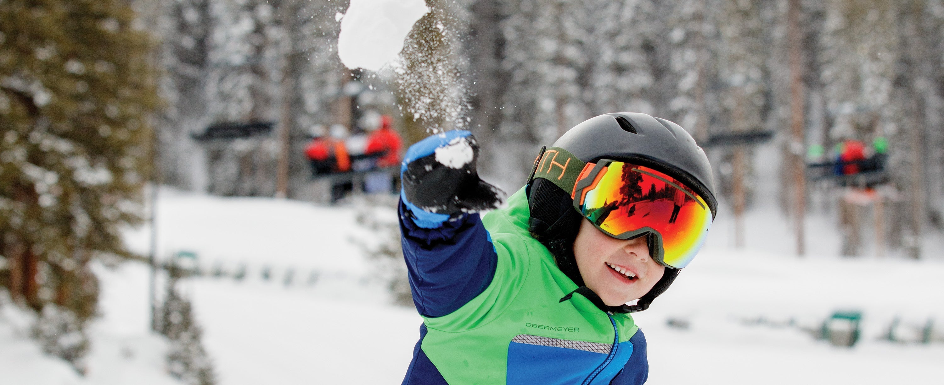 Boy playing in the snow in Obermeyer apparel.