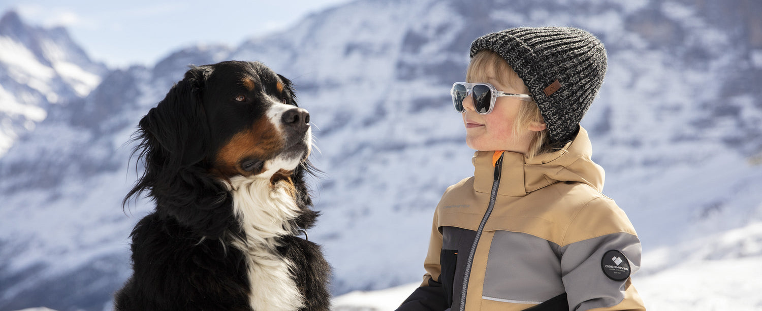 Boy and his dog. Boy is wearing Obermeyer ski apparel and an Obermeyer beanie.
