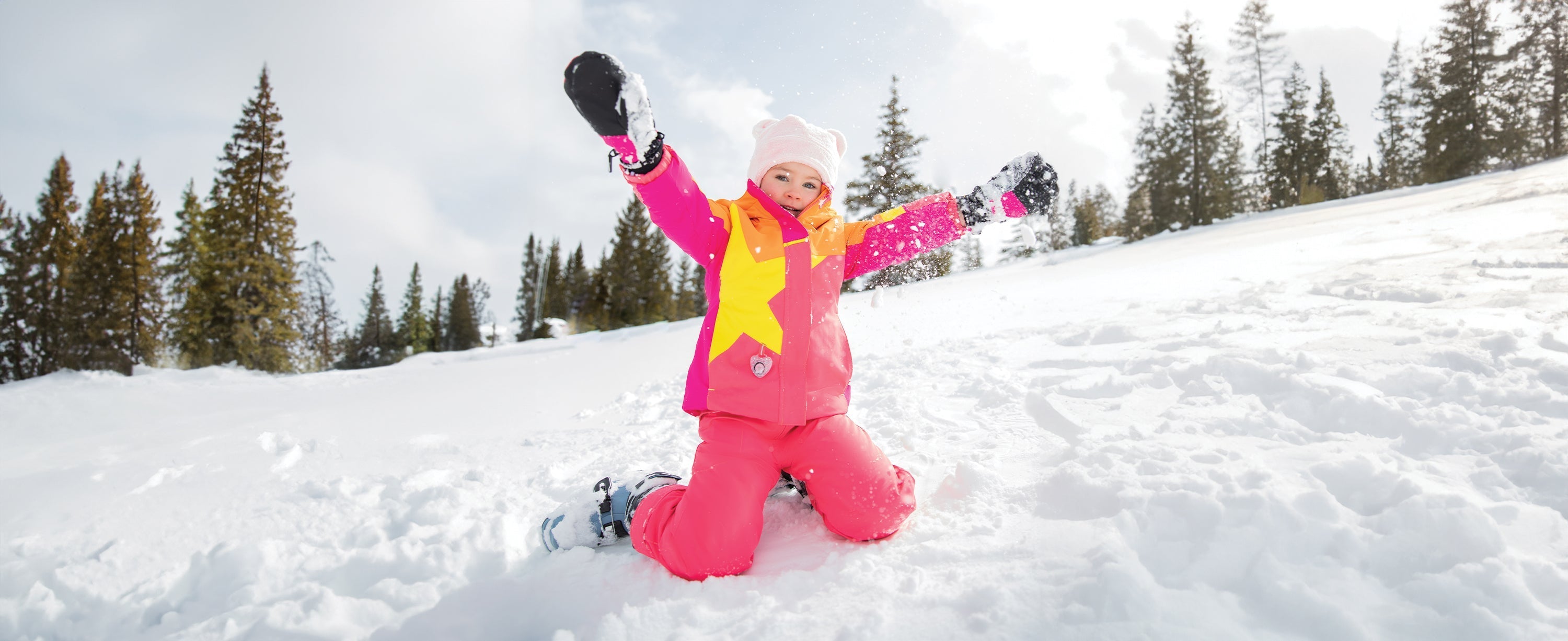 A little girl playing in the snow while wearing Obermeyer.