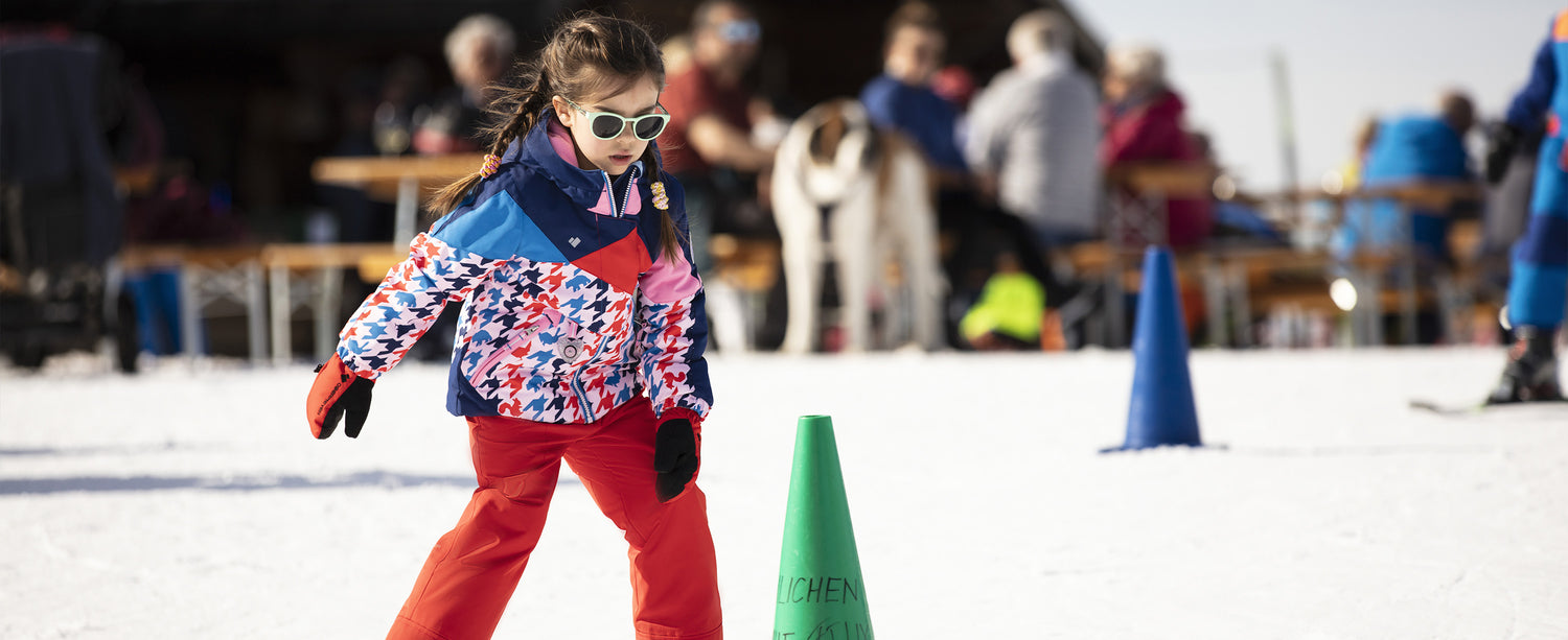Kid girl skier in the snow in Obermeyer apparel.