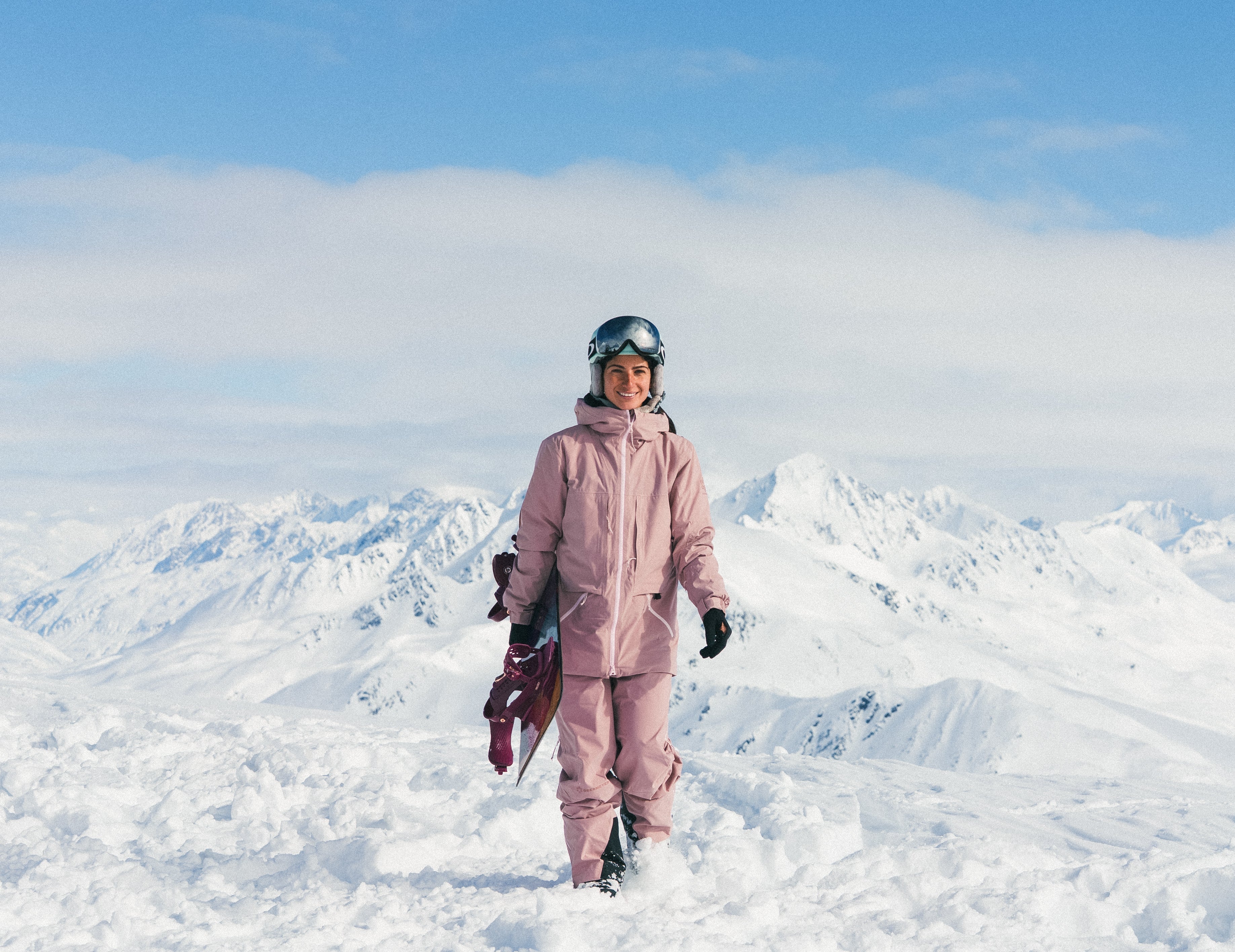 Female Skier jumping out of a tree in an Obermeyer Highlands shell kit.