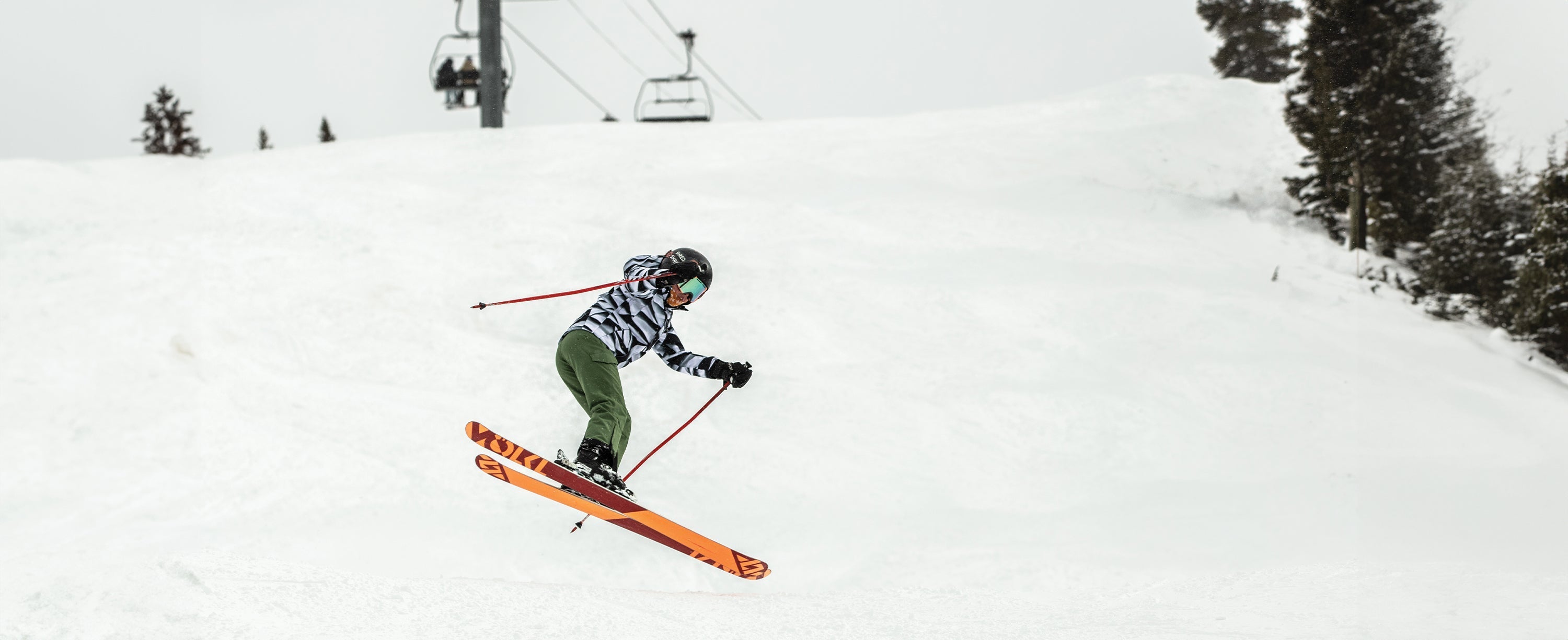 A teen bou jumping on skis while wearing Obermeyer.