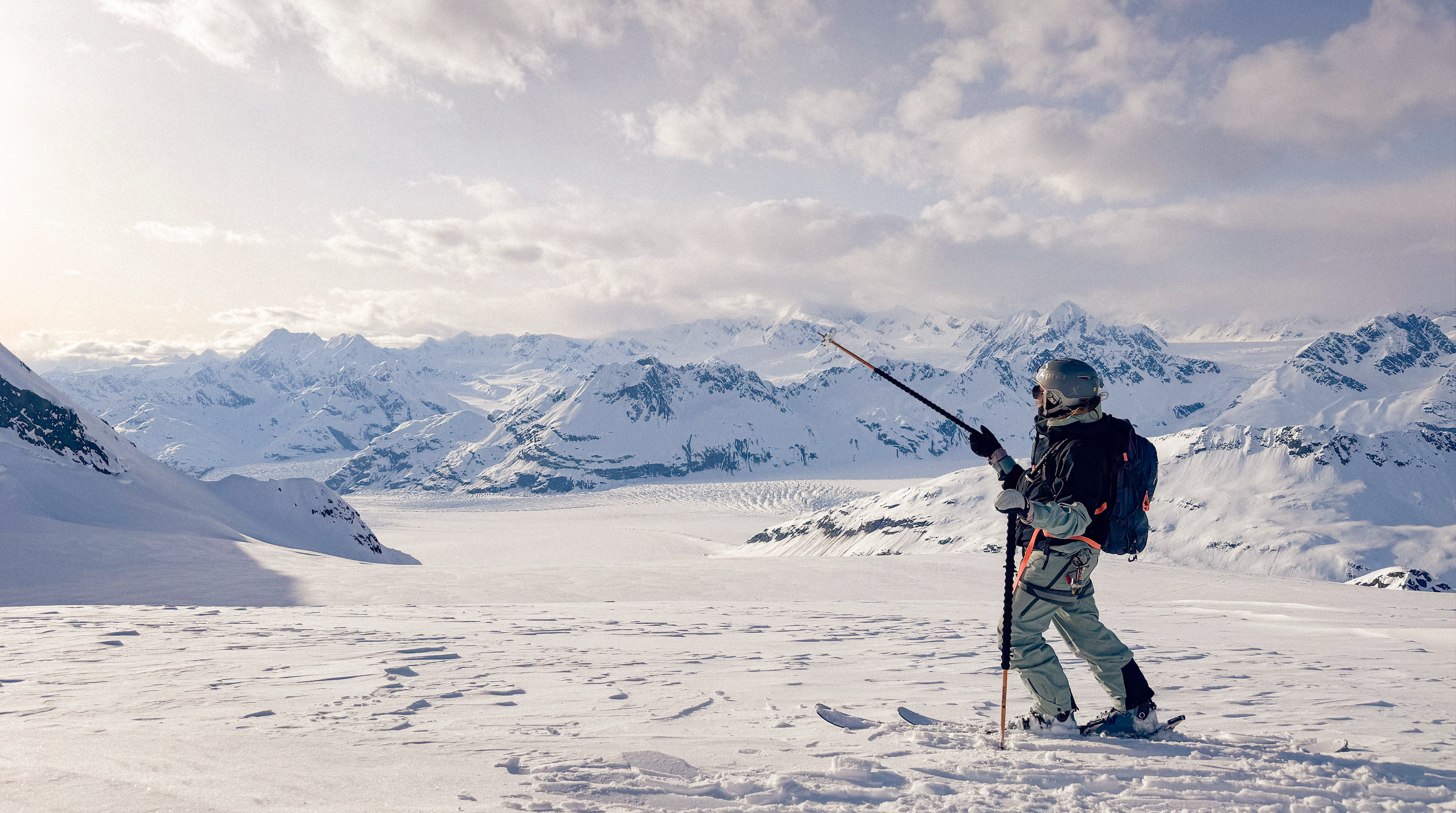 Female skier exiting a helicopter in Obermeyer insulated ski pants.