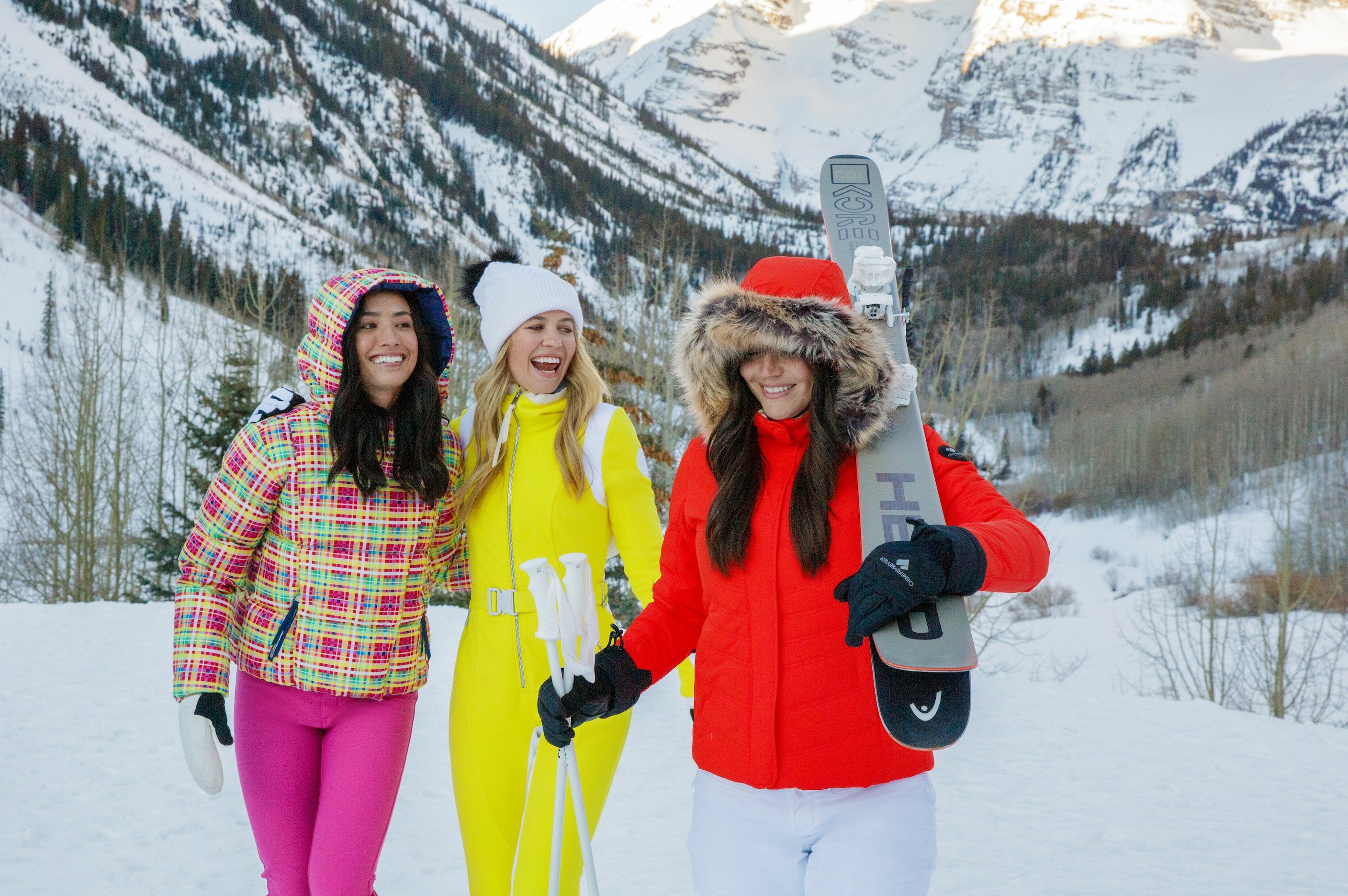 three female skiiers wearing Obermeyer ski apparel.