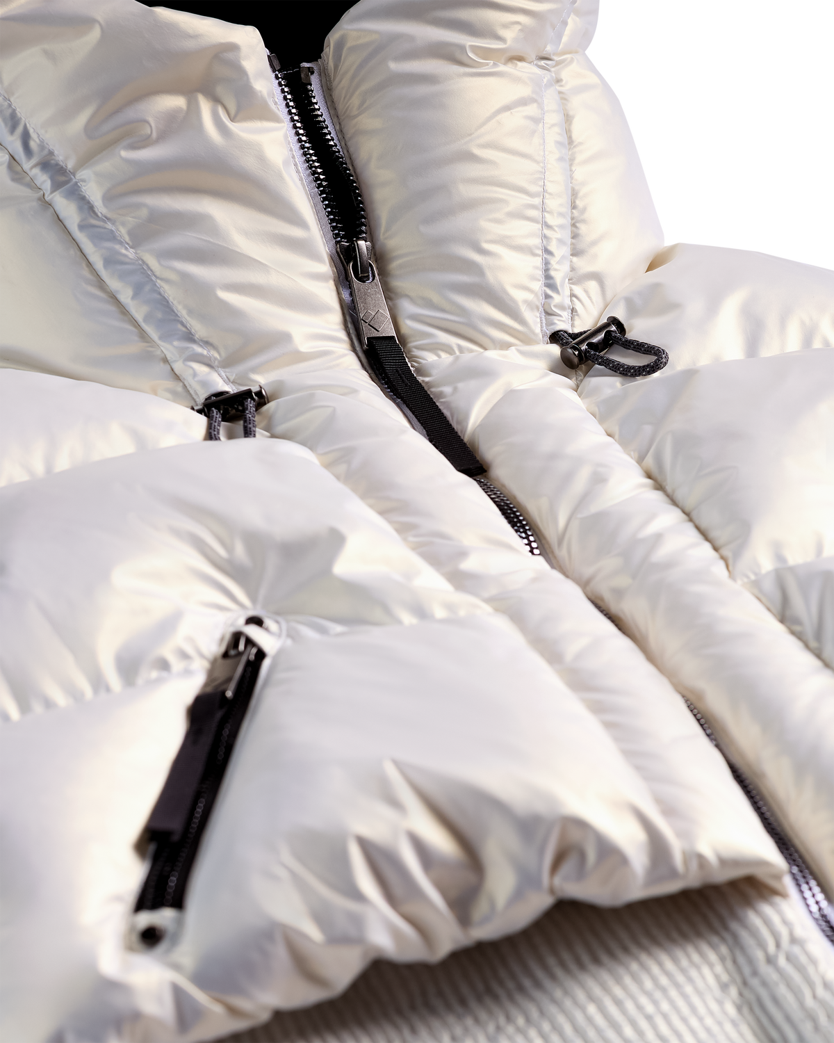
Close-up of a white puffer jacket with black zippers and silver zipper pulls, showing the padded fabric texture and collar detail.