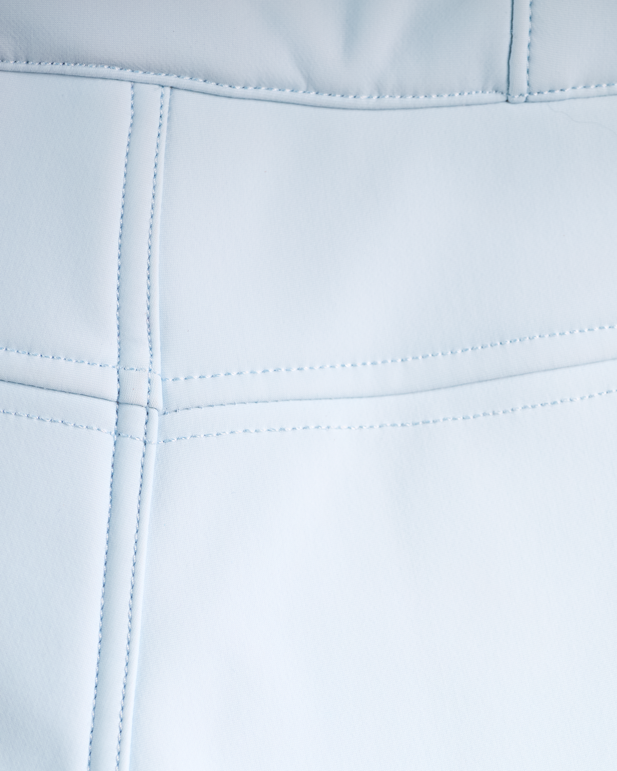 
Close-up of a light blue faux leather or vinyl material with stitched panel seams.