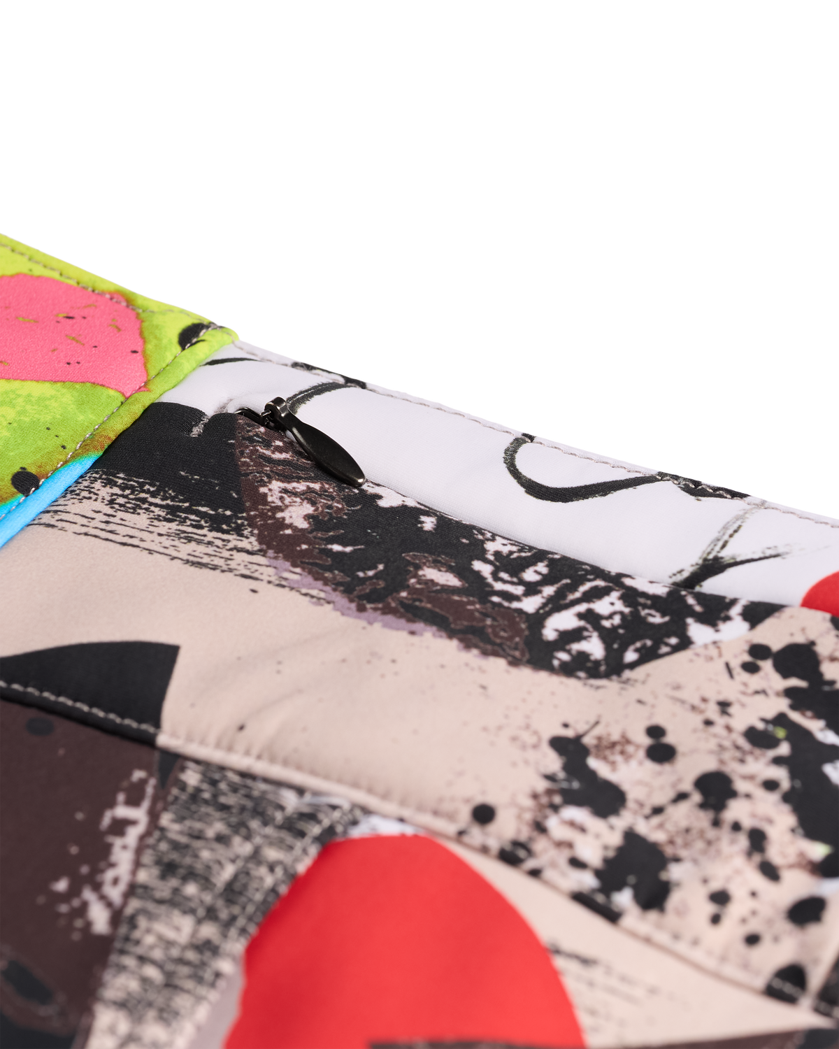 
A close-up of a quilted fabric item, likely a clutch or small bag, featuring a multicolor abstract art print with black, red, pink, green, and beige brushstrokes.