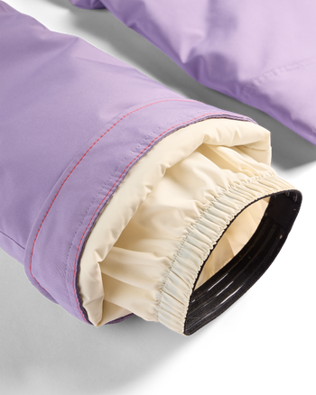 
Close-up of a lavender-purple jacket sleeve cuff with a cream elasticated inner lining and a black outer cuff edge, shown on a white studio background.