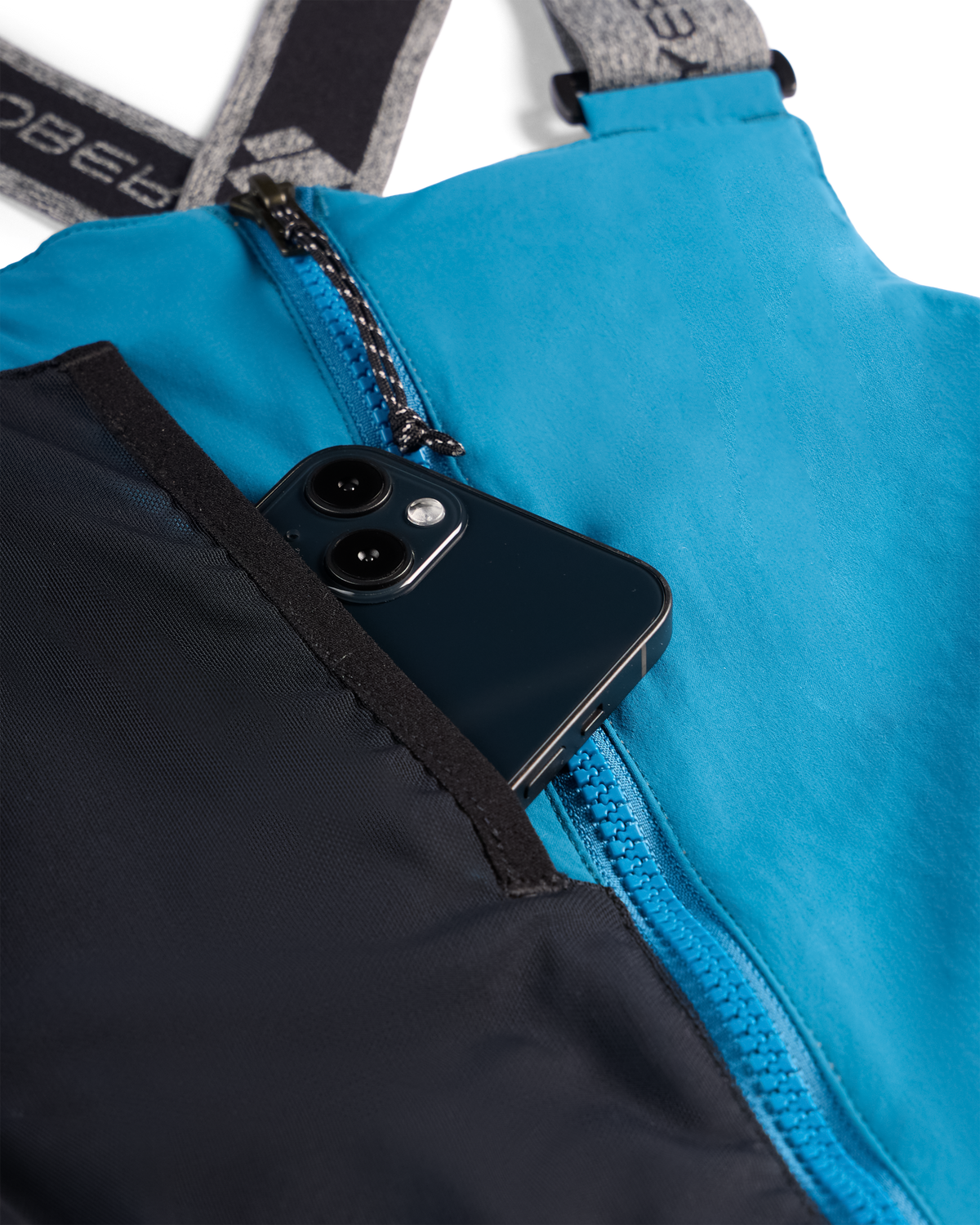 
Close-up of a bright blue and black zippered bag with a black smartphone partially tucked into a front pocket. The bag has gray shoulder straps with white branding text.