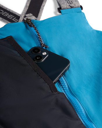 
Close-up of a bright blue and black zippered bag with a black smartphone partially tucked into a front pocket. The bag has gray shoulder straps with white branding text.