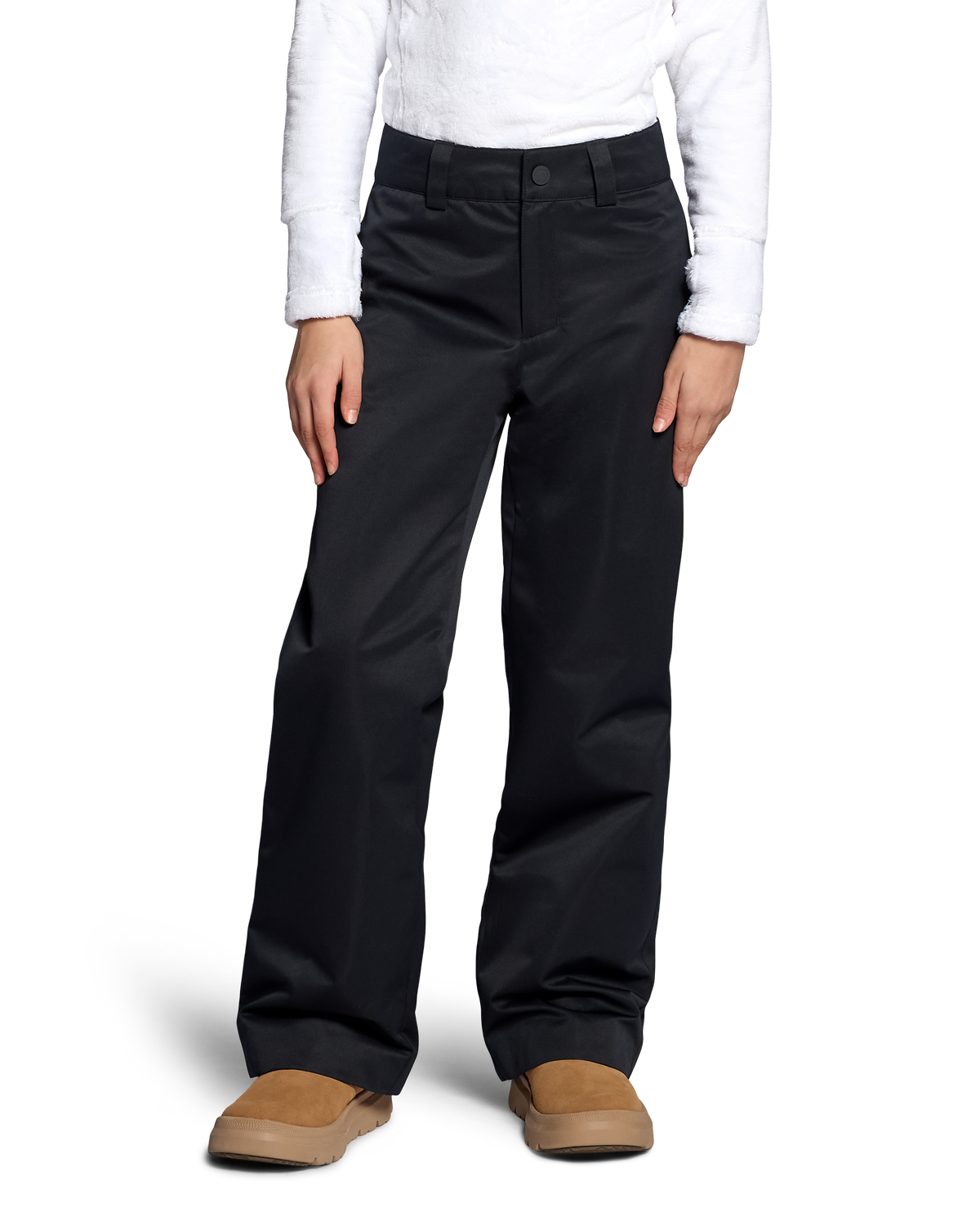 
A person wearing black wide-leg pants with a white long-sleeve top and tan slip-on shoes, shown from the waist down against a light gray studio background.