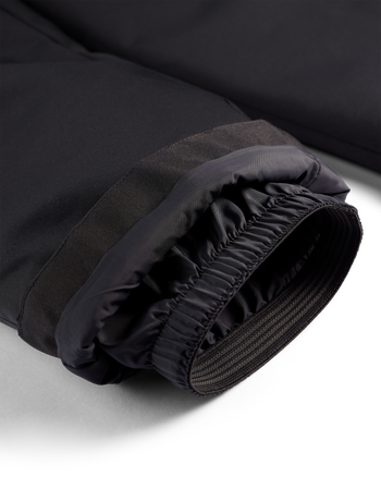 
Close-up of a black insulated jacket cuff with a gathered elastic opening, showing the inner lining and zipper detail on a white background.