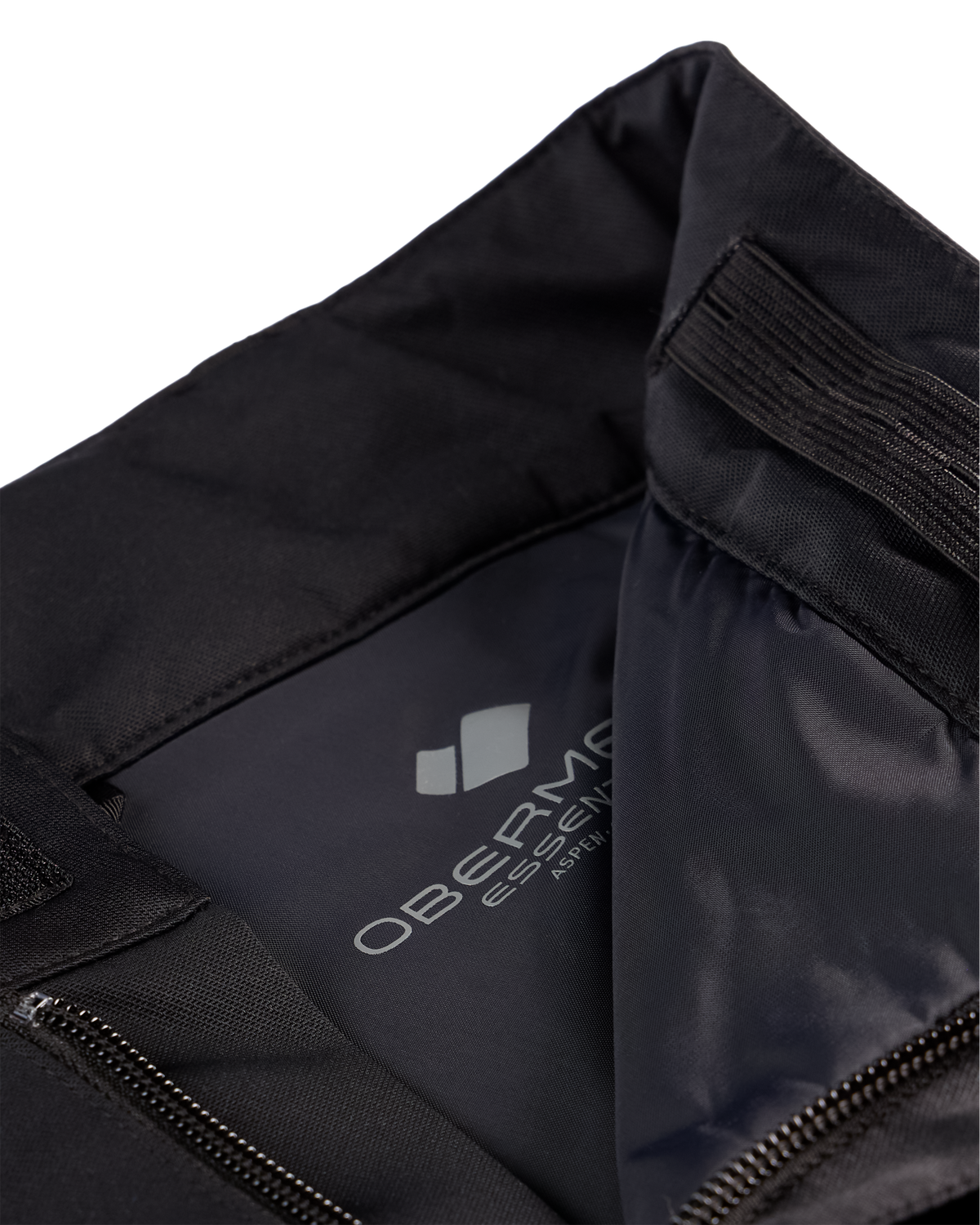 
Close-up of a black athletic jacket or hoodie interior showing the inner collar, elasticized opening, zipper, and a visible gray Obervie Essential interior label.