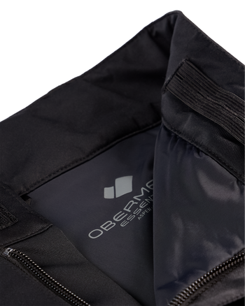 
Close-up of a black athletic jacket or hoodie interior showing the inner collar, elasticized opening, zipper, and a visible gray Obervie Essential interior label.